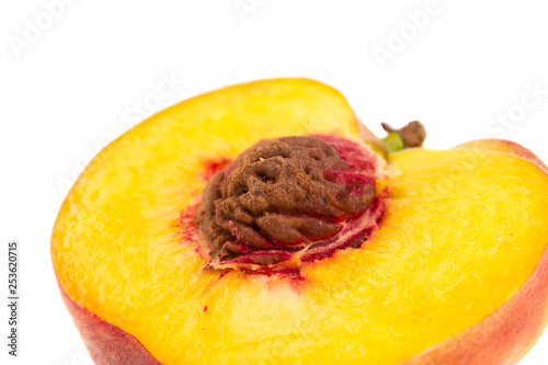 Close up half of a peach with pit isolated on white