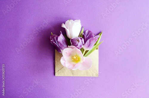 Tulip bouquet and envelope on white wooden background, copy space