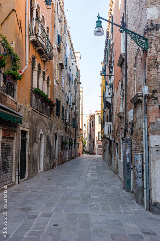 Italy, Venice, a narrow city street with buildings in the background