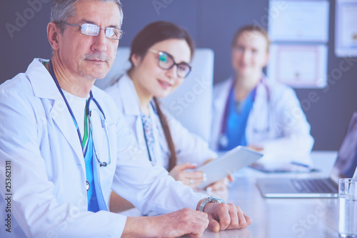 Serious medical team using a laptop in a bright office