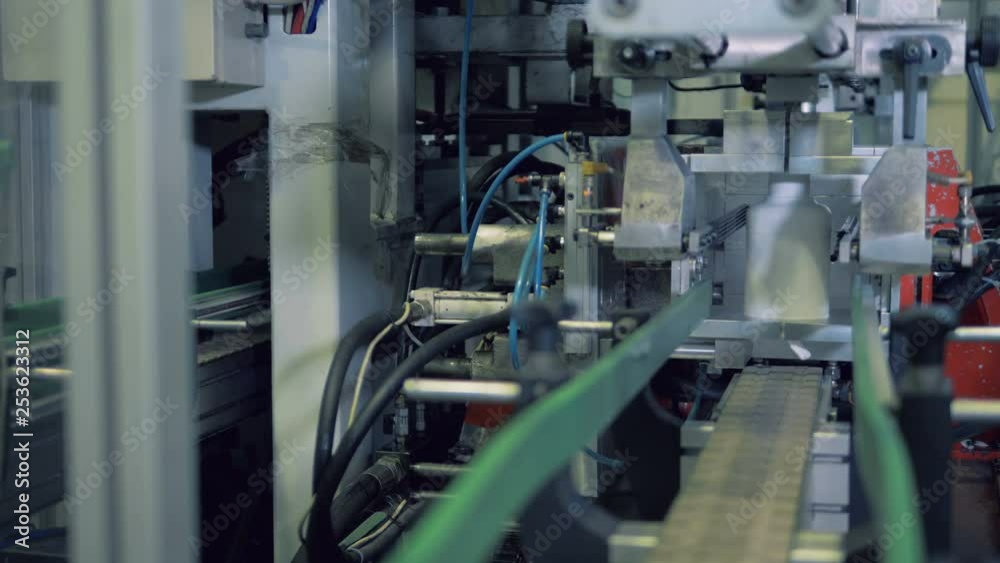 Factory machine is shaping plastic bottles and cutting them off Factory machine is shaping plastic bottles and cutting them off
