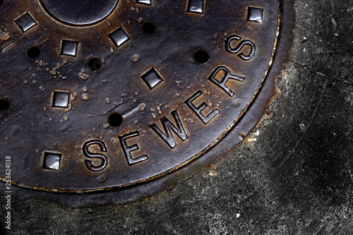 Sewer Cover Man Hole Iron Grate on Street in City
