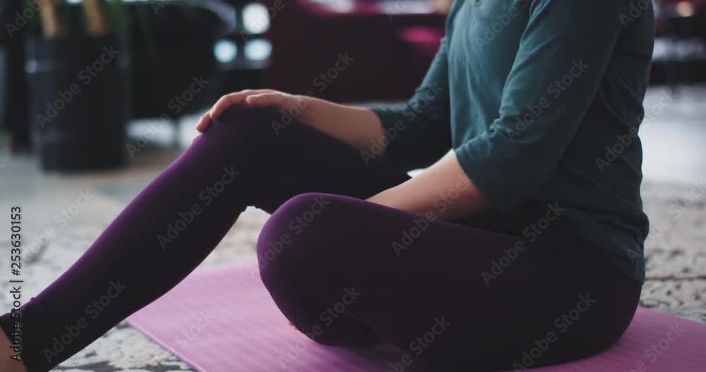 Details stretching body in the morning practicing yoga at home on the mat , in living room wearing comfortable sportswear. Details stretching body in the morning practicing yoga at home on the mat , in living room wearing comfortable sportswear.