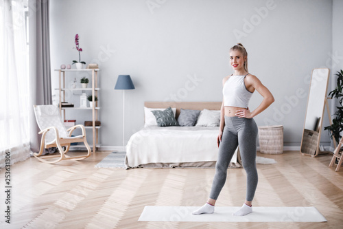 Portrait of a young beautiful sporty woman full at home. © BestForYou