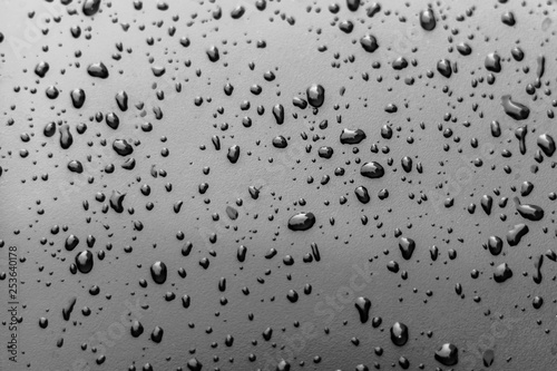 Drops of water on a dark gray metallic surface