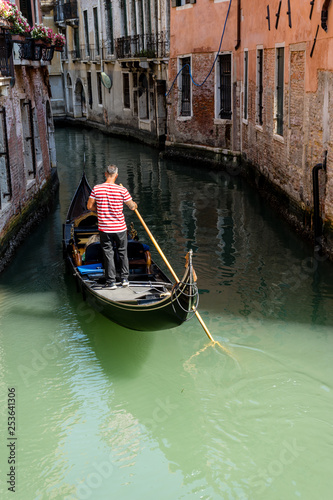 Italy, Venice, Gondolier navigating a gondola near San Moise on a canal