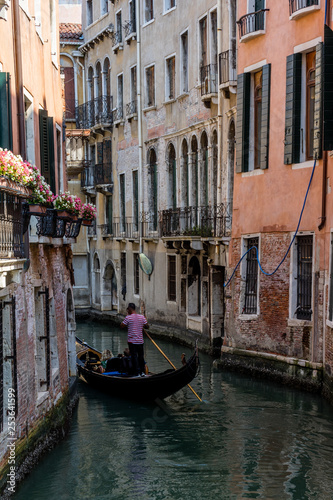 Italy, Venice, Gondolier navigating a gondola near San Moise on a canal