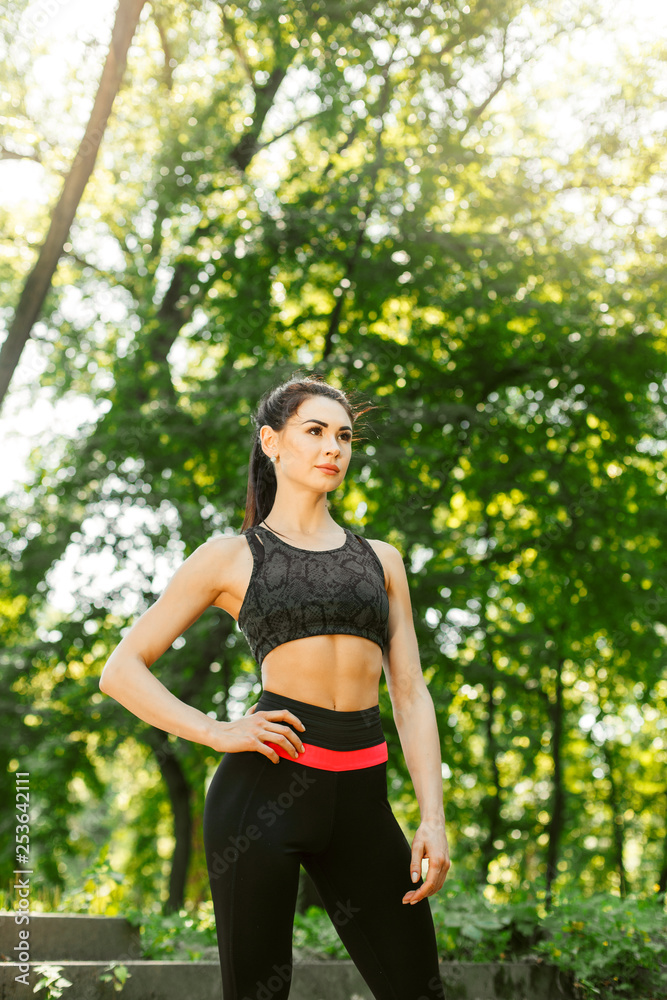 Fitness girl doing stretching warmup exercise before running at the park. Young woman practicing yoga. Female fitness model working out outdoor. Concept of healthy lifestyle. Fitness girl doing stretching warmup exercise before running at the park. Young woman practicing yoga. Female fitness model working out outdoor. Concept of healthy lifestyle.