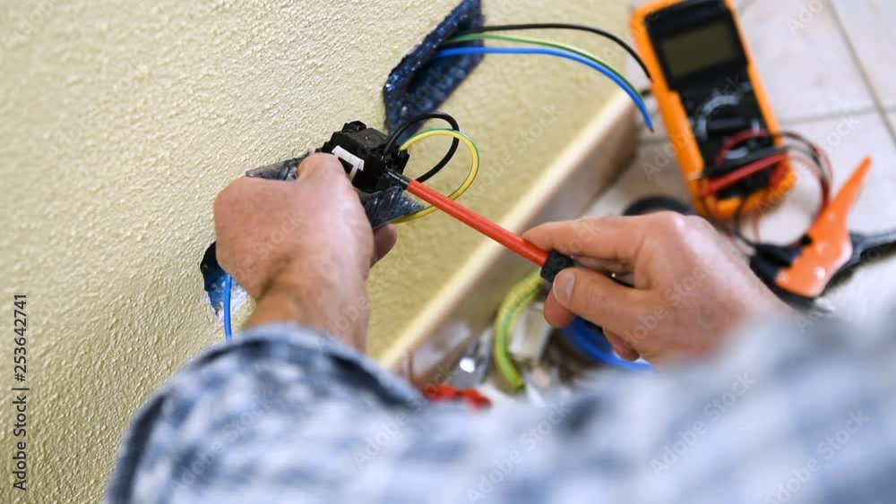 Electrician technician worker inserts and fixes the cables in the electrical socket of a residential electrical system. Construction industry. Building. Footage.