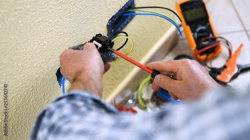 Electrician technician worker inserts and fixes the cables in the electrical socket of a residential electrical system. Construction industry. Building. Footage. 