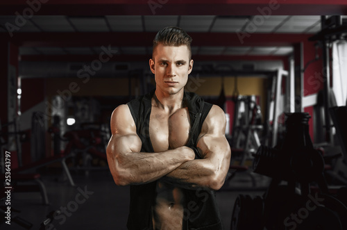 Muscular model sports young man exercising in gym. Portrait of sporty healthy strong muscle. Fitness trainer. Sport workout bodybuilding motivation concept. Sexy torso.