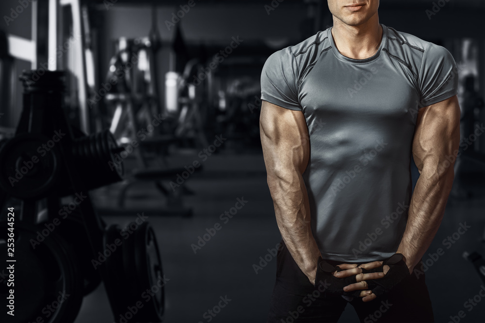 Muscular model sports young man exercising in gym. Portrait of sporty healthy strong muscle. Fitness trainer. Sport workout bodybuilding motivation concept. Sexy torso. Muscular model sports young man exercising in gym. Portrait of sporty healthy strong muscle. Fitness trainer. Sport workout bodybuilding motivation concept. Sexy torso.
