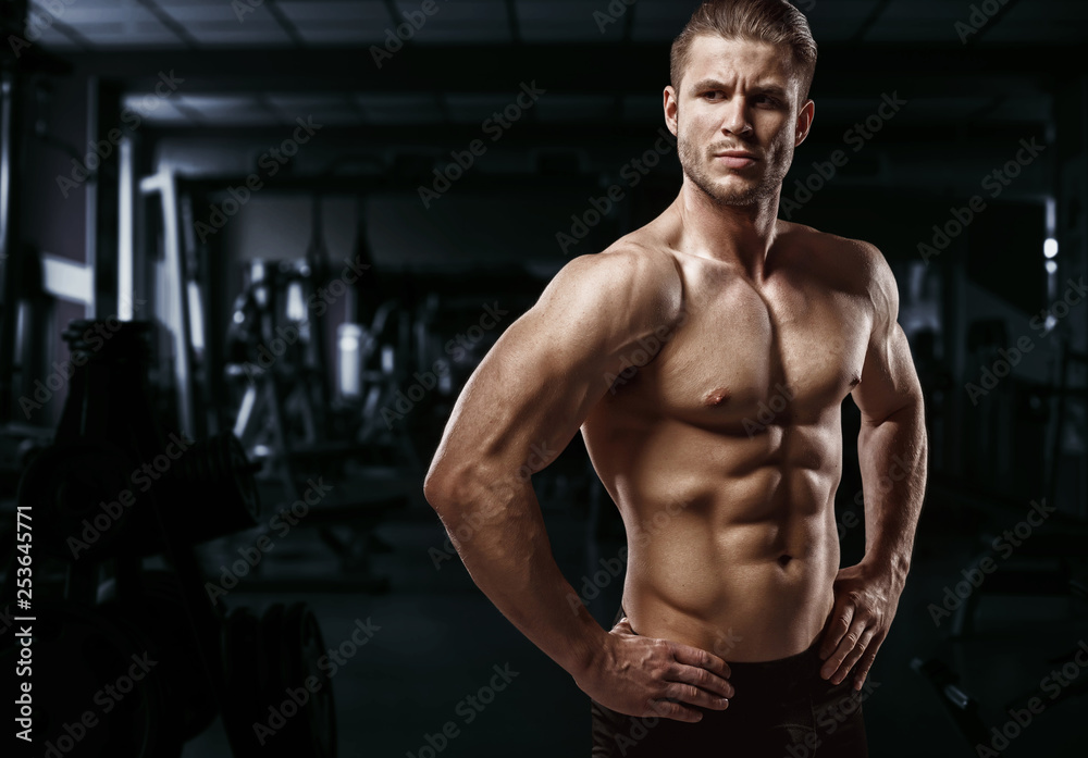 Muscular model sports young man exercising in gym. Portrait of sporty healthy strong muscle. Fitness trainer. Sport workout bodybuilding motivation concept. Sexy torso. Muscular model sports young man exercising in gym. Portrait of sporty healthy strong muscle. Fitness trainer. Sport workout bodybuilding motivation concept. Sexy torso.