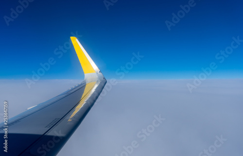 Netherlands, Hague, Schiphol, a blue and yellow airplane is flying in the sky