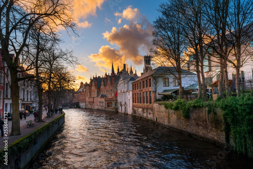 Bruges, Belgium. Medieval ancient houses made of old bricks at water channel with boats in old town