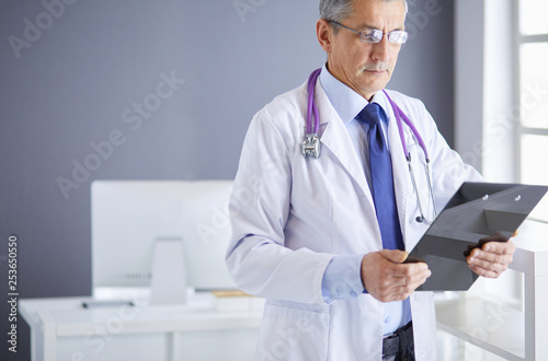 Male doctor writes notes on the clipboard in the hospital