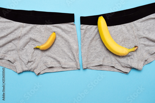 baby banana compare size with big banana on male panties on blue background. photo