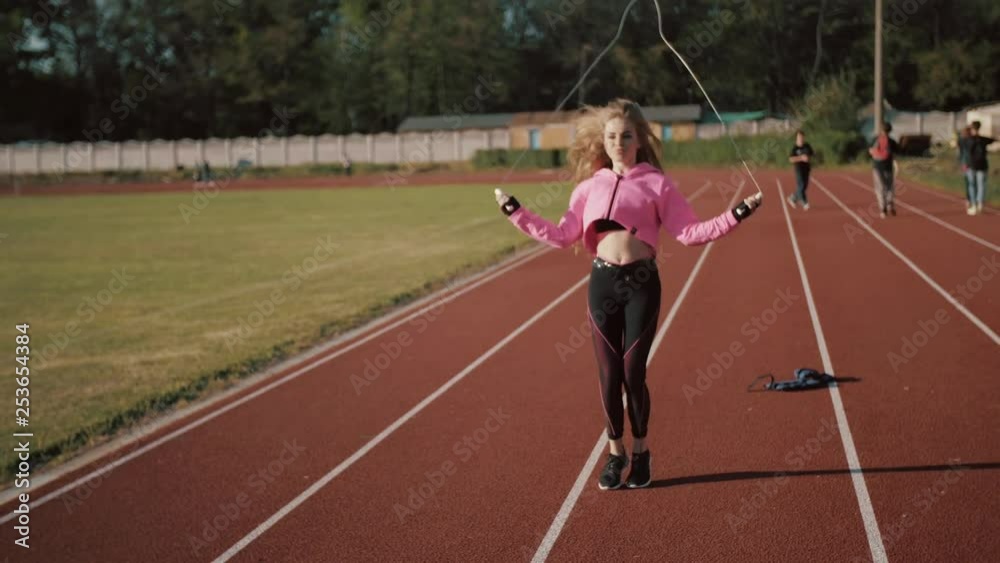 Close up of fitness-woman feet jumping, using skipping rope in stadium Close up of fitness-woman feet jumping, using skipping rope in stadium