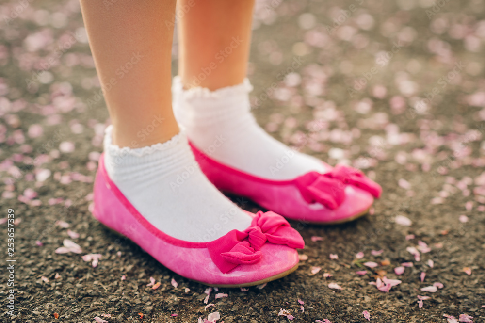 Close up image of beautiful pink ballerina shoes wearing by young girl