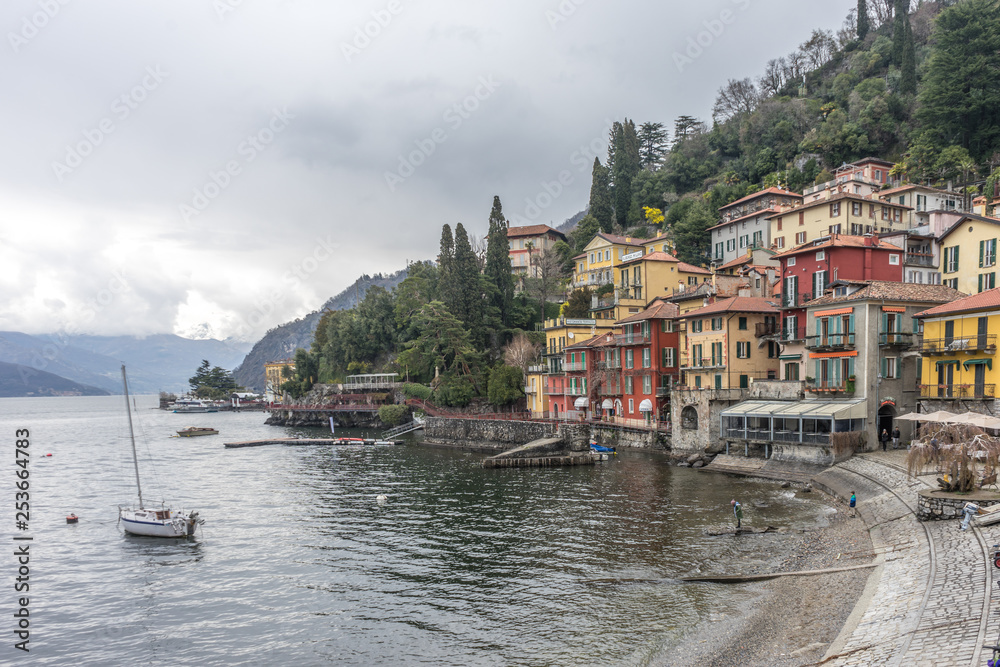Italy, Varenna, Lake Como, Lake Como, a small boat in a body of water with buildings in the background with Lake Como in the background