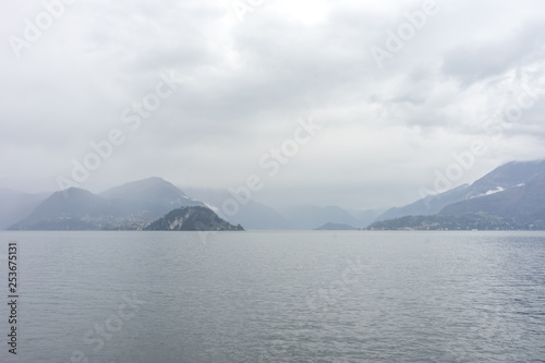 Italy, Varenna, Lake Como, a large body of water with a mountain in the background © SkandaRamana