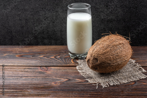 Coconut milk on dark wooden background.