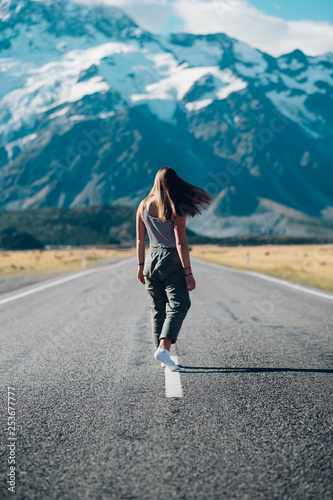 Portrait of girl walking down road toward mountains