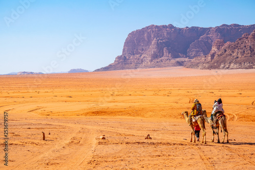 Tourists on camels crossing wadi rum desert in Jordan