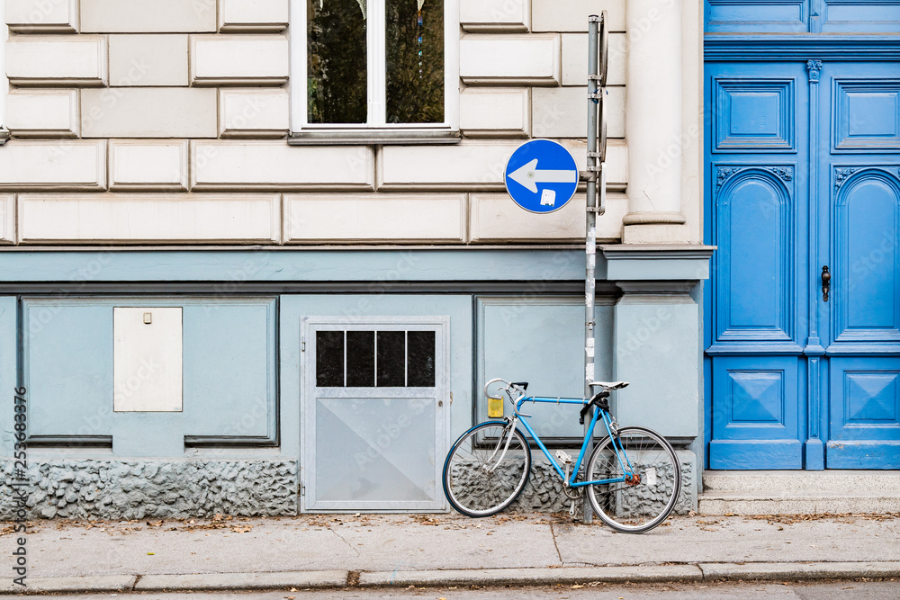 Blue bicycle parked on a sidewalk