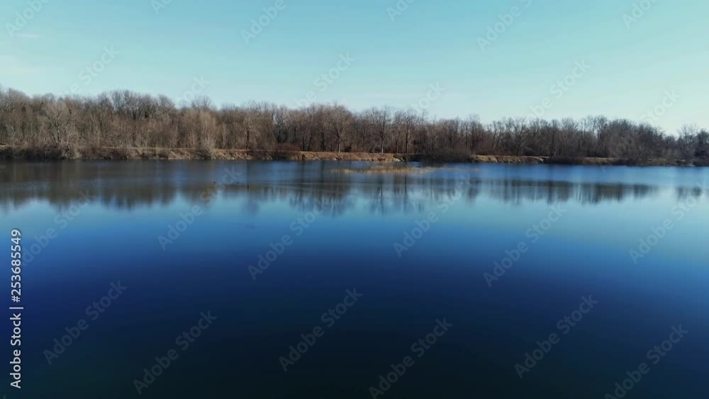 Aerial view of a lake forward moving over trees Aerial view of a lake forward moving over trees