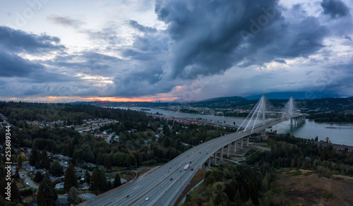 Aerial panoramic view of Trans Canada Highway near the Port Mann Bridge during a dramatic cloudy sunset. Taken in Surrey, Vancouver, BC, Canada.