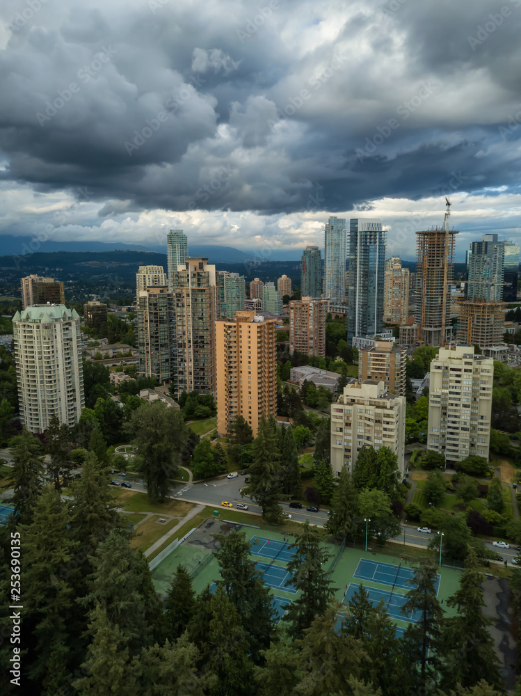 Aerial view of residential homes in a modern city during a vibrant summer cloudy day. Taken in Burnaby, Vancouver, BC, Canada.