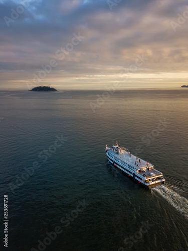 Aerial view of a ferry boat in the ocean during a vibrant cloudy sunset. Taken in Horseshoe Bay, West Vancouver, British Columbia, Canada. © edb3_16