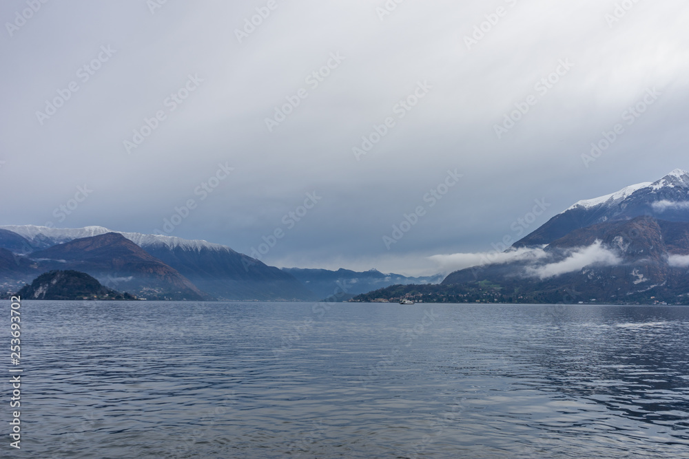 Italy, Varenna, Lake Como, a large body of water with a snowcap mountain in the background