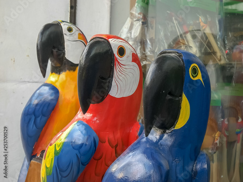 close up of three large carved wooden macaws in rio photo