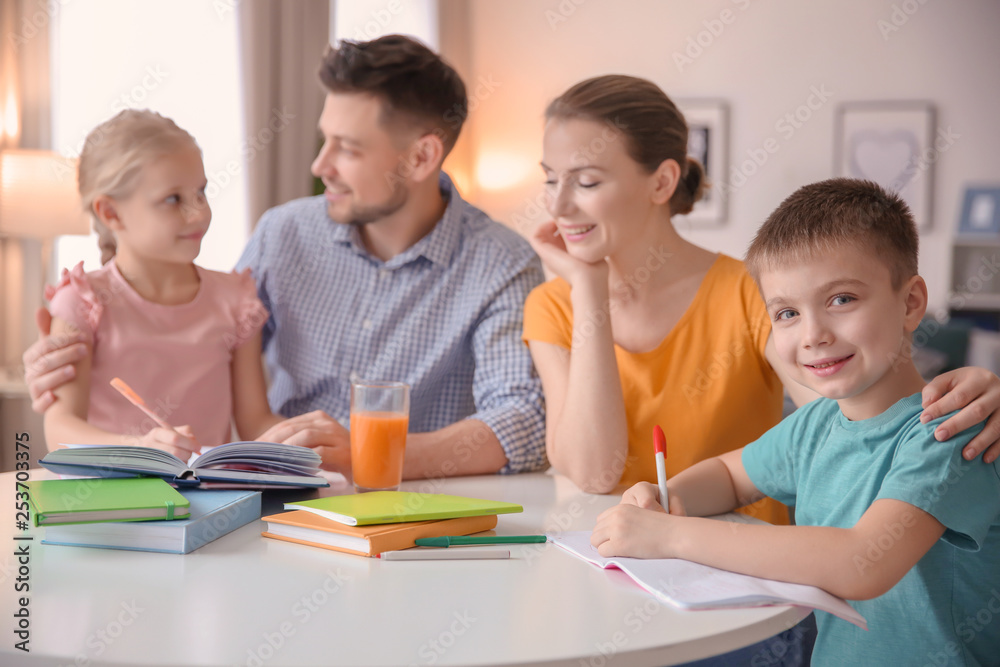 Little children with parents doing homework at home
