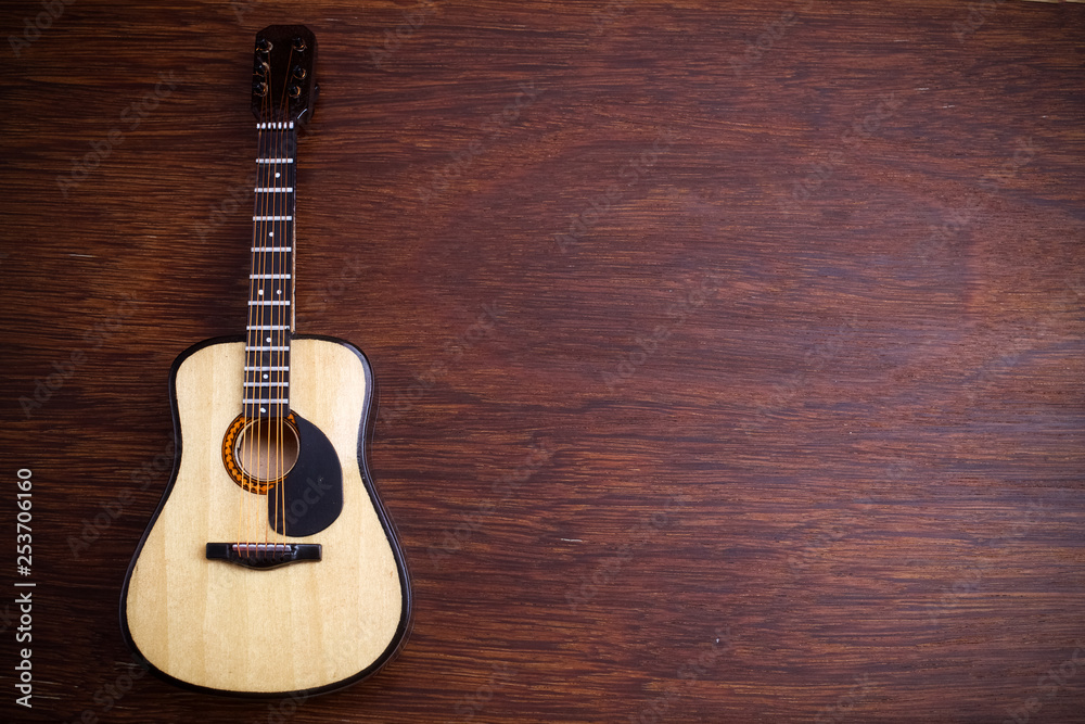 Obraz premium Acoustic guitar against an old wooden background.