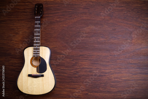 Acoustic guitar against an old wooden background.