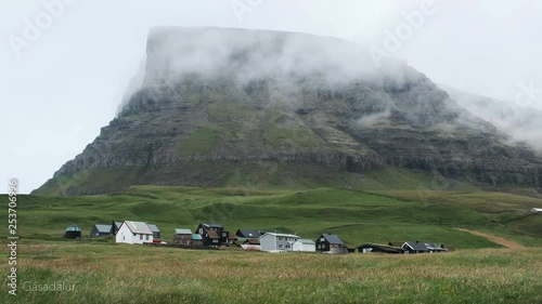 Shot of a small village at Gásadalur on Faroe Island in foggy weather photo