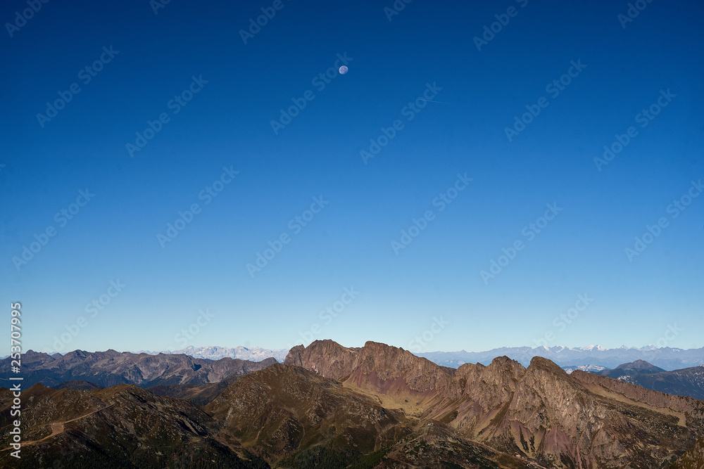 Fototapeta premium Moon over Lagorai Mountains chain, Primiero, Trentino, Italy 
