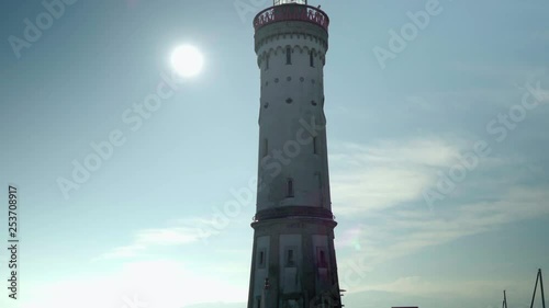 Light tower on european harbor with sun flares photo