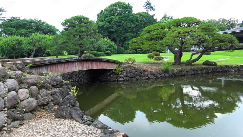 Wooden bridge in the traditional Japan garden with tree reflection on lake Wooden bridge in the traditional Japan garden with tree reflection on lake
