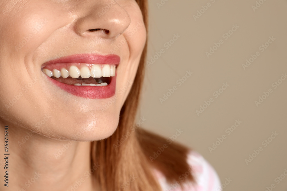 Fototapeta premium Smiling woman with perfect teeth on color background, closeup. Space for text