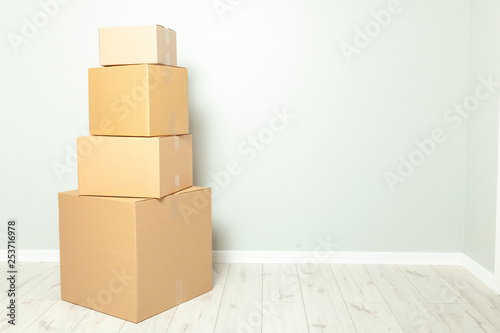 Day moving. Delivery of goods, shopping. Cardboard boxes on gray wall background. Copy space for text.