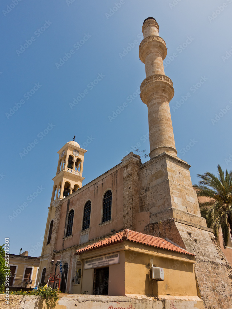 Orthodox church and muslim mosque side by side at the old venetian harbor, city of Chania, Crete island, Greece