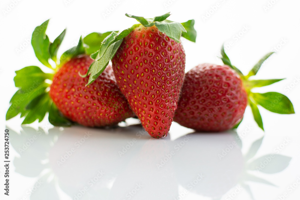 Group of red strawberries with green leaves Group of red strawberries with green leaves