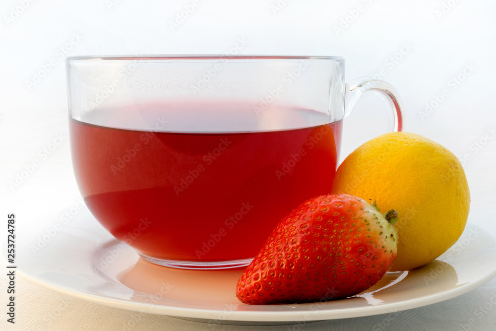 Glass cup of hot aromatic red tea with strawberry and lemon Glass cup of hot aromatic red tea with strawberry and lemon