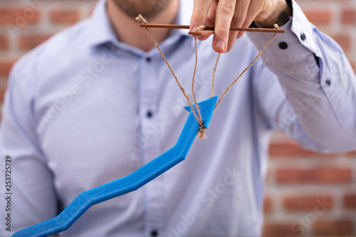 Valokuva Person's Hand Manipulating Blue Arrow With Rope