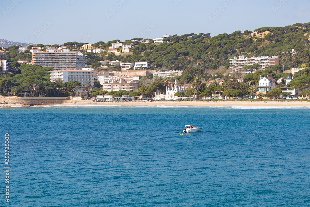 Leisure boat on the blue Mediterranean Sea close to a beach resort in Costa Brava, Catalonia