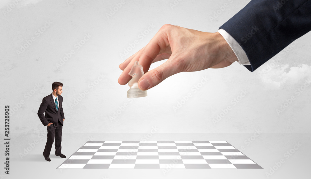 Little businessman thinking about chess strategy with a big hand concept
Little businessman thinking about chess strategy with a big hand concept
